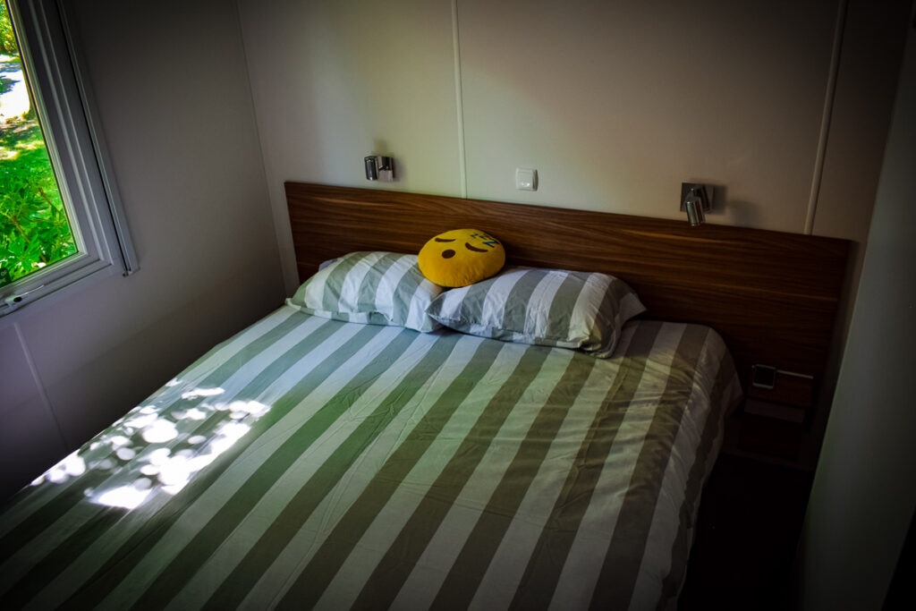 size of the double bedroom in the Azure plus formerly known as the avant mobile home from eurocamp. bed with stripey bedding and mr snooze emoji on top of the bed