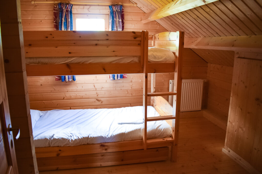 Bunk bedroom with wooden bunk bed in the 4 bedroom villa lodge made out of wood at la croix du vieux pont berny riviere france with eurocamp