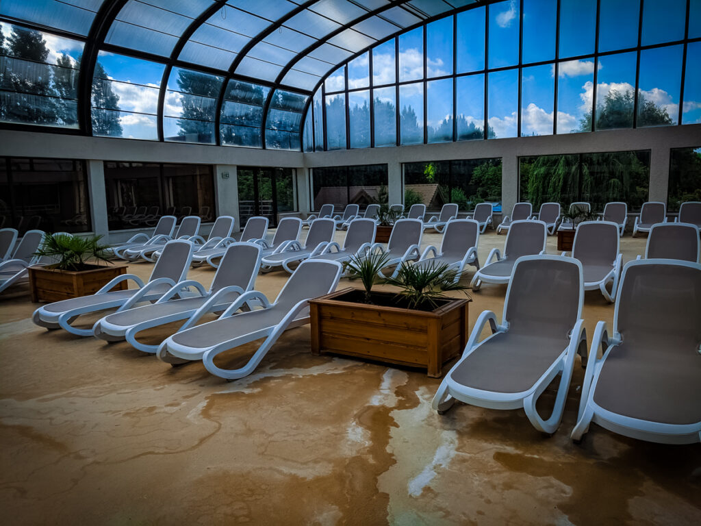 there are so many sun lounbgers inside at the pool area of camping La Croix du vieux pont berny riviere france (66)