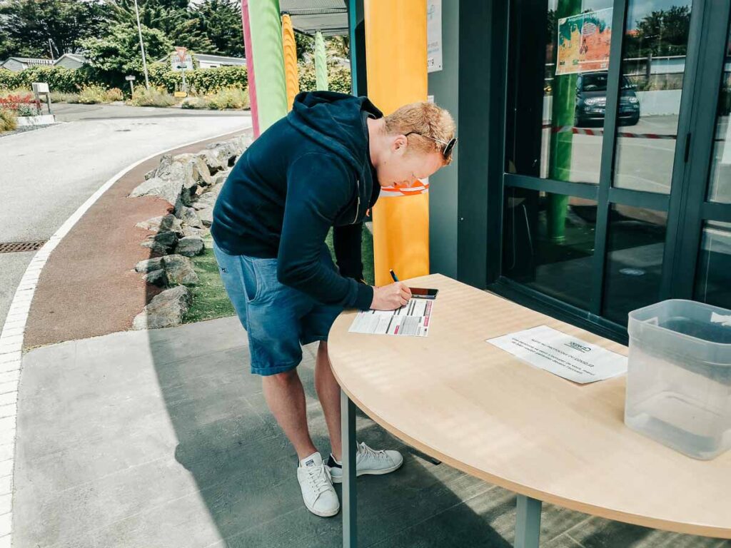 Mike filling in reception forms at the campsite reception Camping de l'ocean Brem Sur Mer