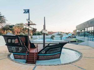 Outdoor pool with a pirate ship play area at Camping de l'ocean Brem Sur Mer