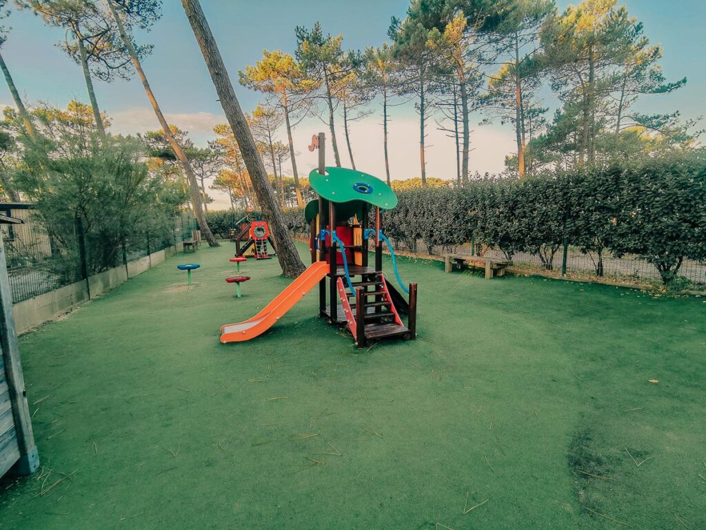 The astroturffed kids play park with view of pine trees in background at camping le vieux port by Resasol in Messanges, Landes department, France