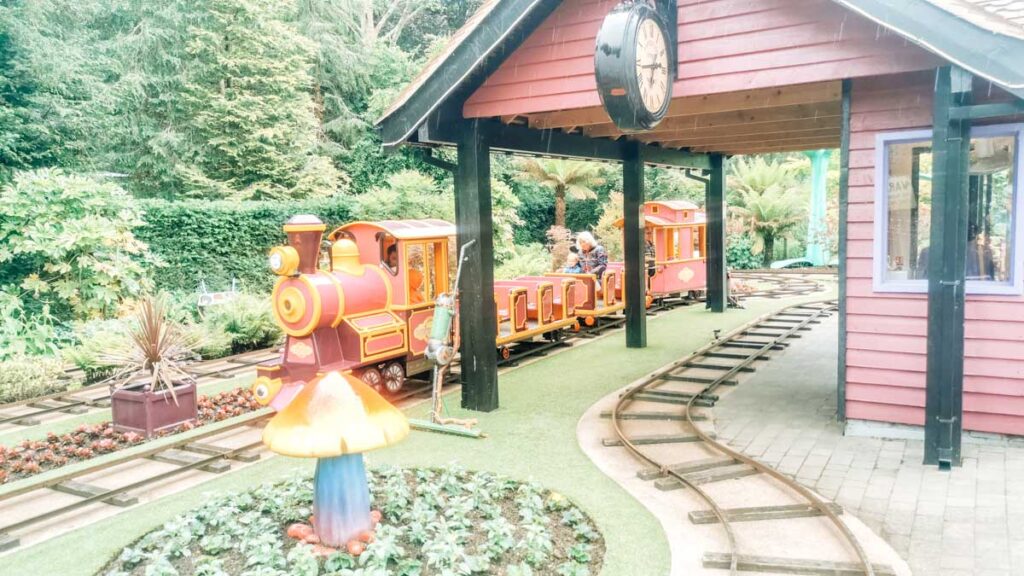 the train in critter creek with the toddler and her nanny riding in the middle seats at Paultons-park-and-peppa-pig-world