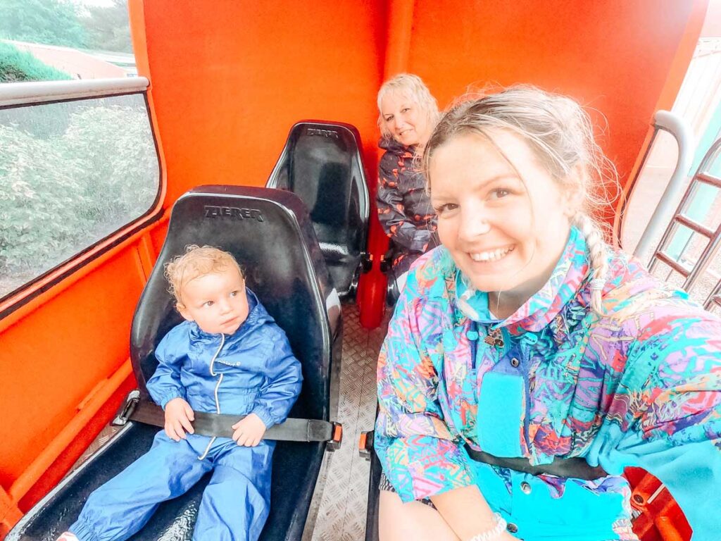 soaking wet in our rain macs on the helicopter ride in peppa pig world at paultons park