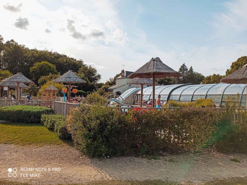 outside of the pool area with bushes surrounding the outside at camping la roche posay