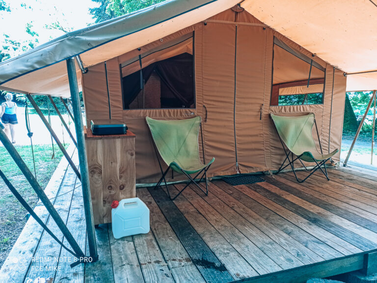 Canvas safari tent with chairs on a wooden deck