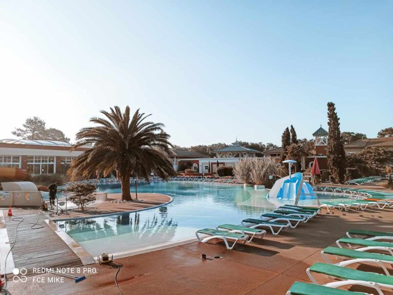 Outdoor pool with sun loungers and palm trees at Yelloh Village Sylvamar