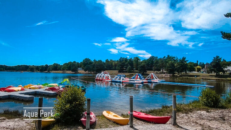 Aqua park with an obstacle course on a lake, kayaks moored nearby