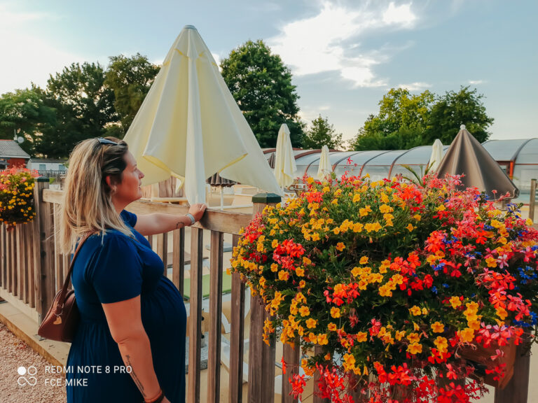 A woman standing beside a flower display at Homair Le Soleil des Landes