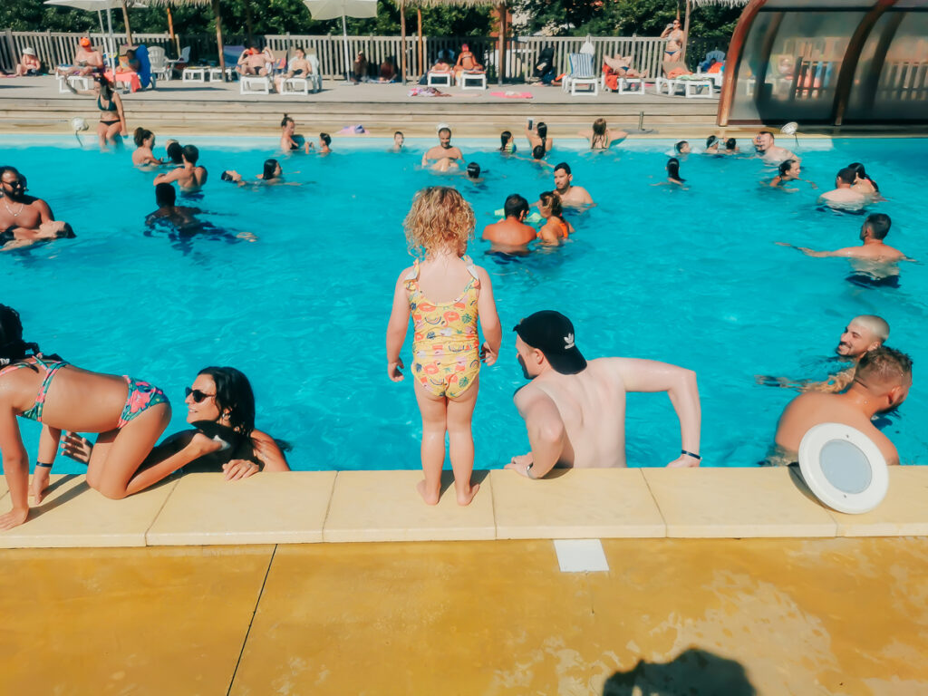 a very busy pool area with lots of people in