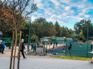 other half of play area with older children playing and a sports court