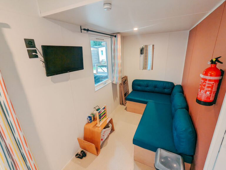 Living area with a sofa bed inside a mobile home at La Chapelle