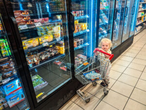 toddler with minature trolley in a supermarket