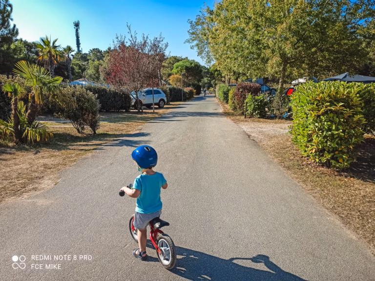 child enjoying a campsite on her balance bike