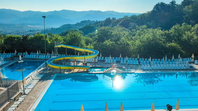 Swimming pool with a yellow water slide at Norcenni Girasole, Tuscany