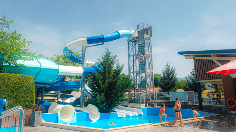 Outdoor pool with a tall water slide tower at Les Fontaines, Annecy