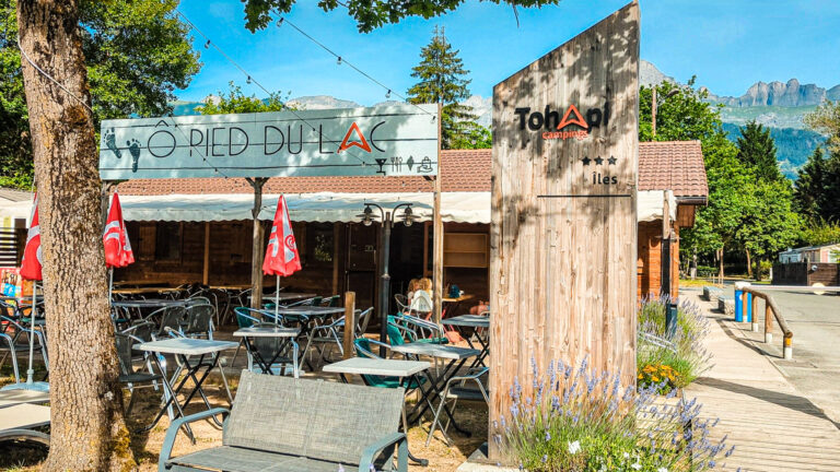 Bar and restaurant terrace beside a lake at Flower Camping Les Iles, Passy