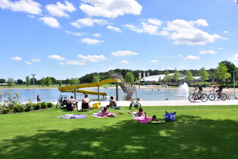 eurocamp netherlands site Ter Spegelt beach lake view with waterslide and people relaxing