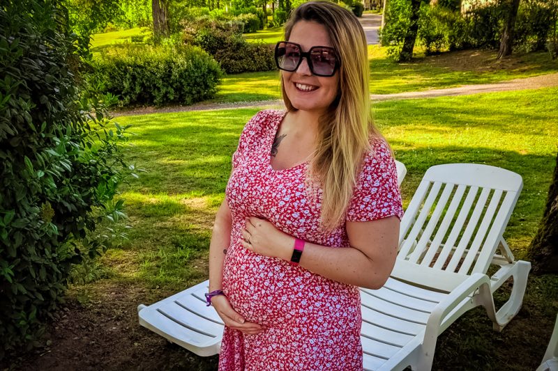 Breanne Family Camping Europe Pregnant Breanne Family Camping Europe Pregnant bump in a red patterned dress on a campsite